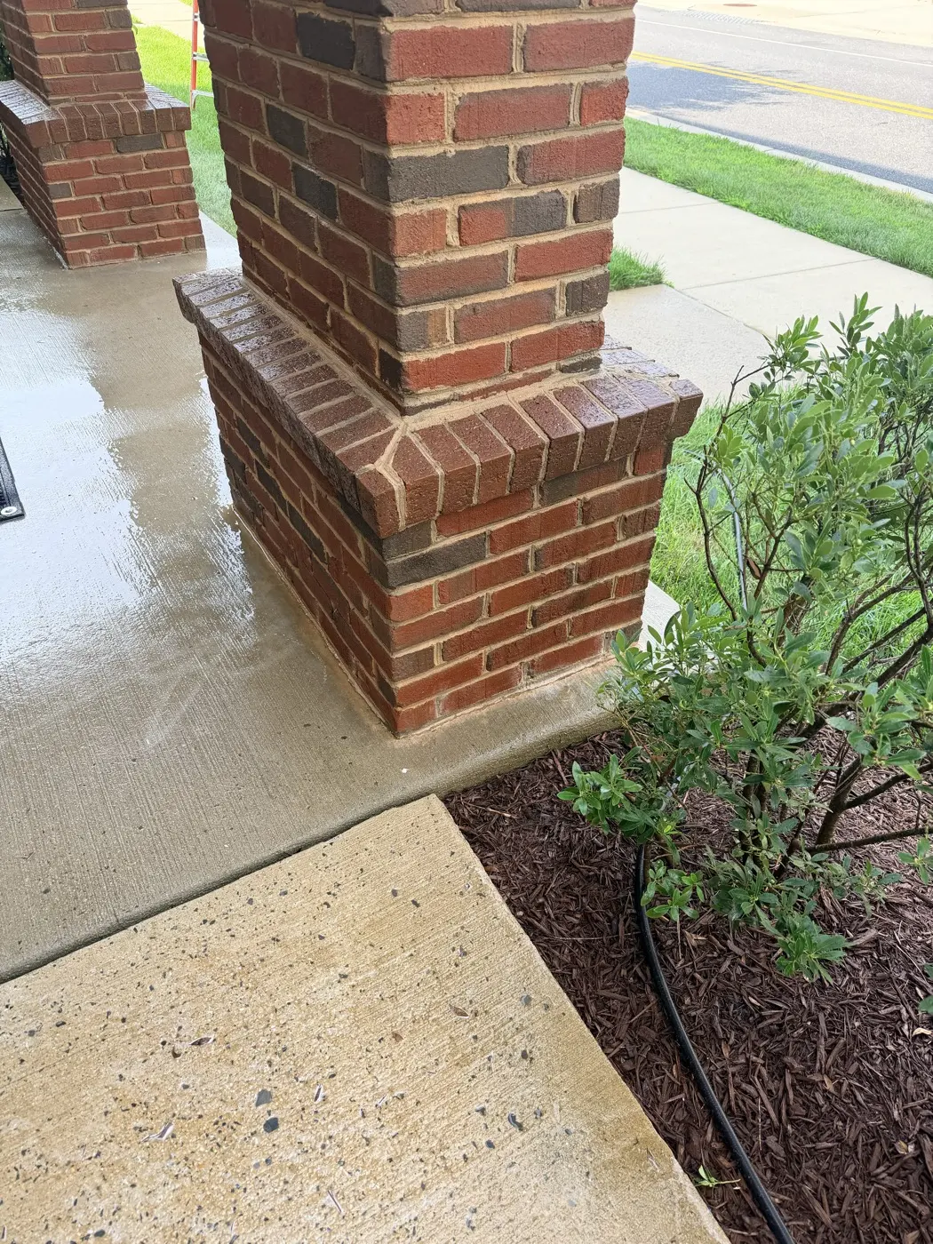 The same brick column after soft washing, with the brick and mortar back to their original color.